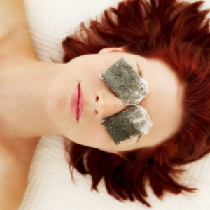 Woman with tea bags on her eyes