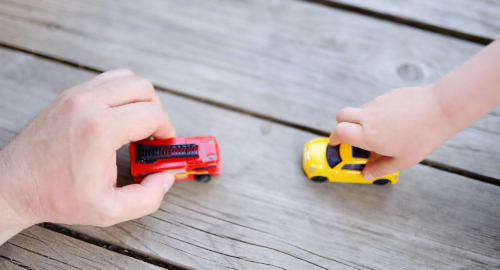 Hands playing with toy cars